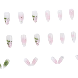 Pink and green almond press-on nails with delicate floral designs and pearl accents