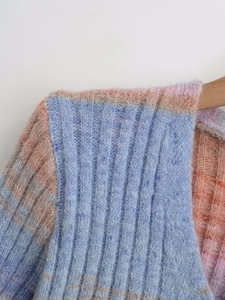 Detailed close-up of vibrant gradient knit sweater with vertical ribbed texture