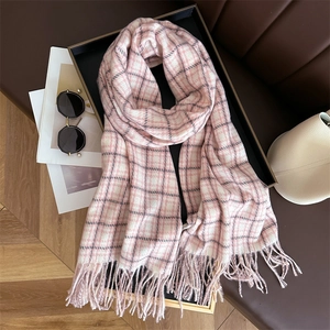 Detail of pink and white plaid scarf with fringe in a stylish autumn still life setting