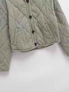 Gros plan sur la veste matelassée en velours côtelé vert sauge avec boutons et poches