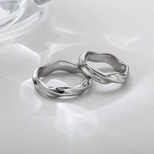 Anelli Mobius moderni in argento per coppia con design lucido a onde vista dall'alto