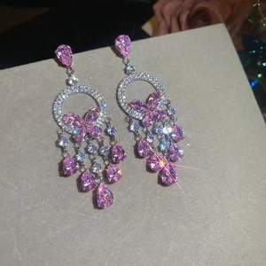 Gros plan de boucles d'oreilles papillon roses avec pampilles en zircon et effet brillant