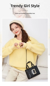 Close-up of a black croc-effect handbag with a large metal buckle in a lifestyle setting