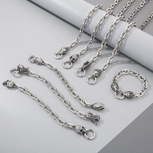 Detailed shot of silver steel chains featuring skull, snake, and lion head charms