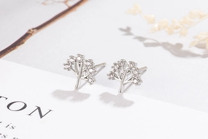 Close-up of silver tree of life earrings with sparkling pavé cubic zirconia details