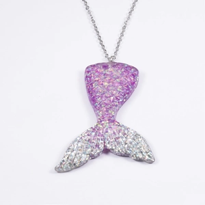 Macro-opname van paarse zeemeerminstaart hanger met glitter schubben en zilveren staartvin