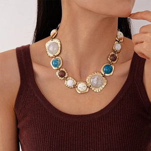 Detail shot of vintage geometric resin collar necklace with gold accents and marble textures