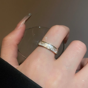 Detail of 18k gold plated double layer cross ring with zircon and mother of pearl inlay