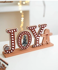 Detail of wooden JOY Christmas sign with gingerbread man and festive warm lights