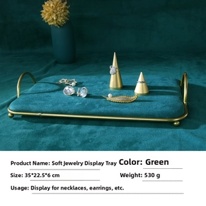 Close-up of green velvet jewelry stand for necklaces and earrings with gold metal frame