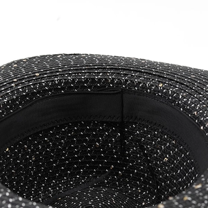 Detailed close-up of the black woven straw hat interior with sequins and sweatband