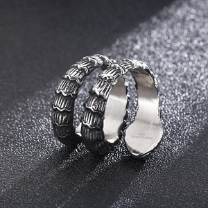Retro punk style stainless steel snake ring with textured silver scales on black background