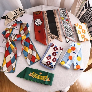 Flat lay of diverse floral and geometric patterns on silky long narrow hair scarves