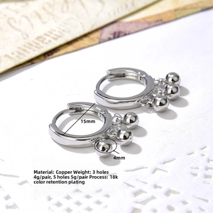 Detailed macro view of 18k silver plated copper hoop earrings with polished beads