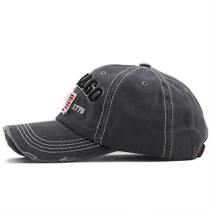 Détail d'une casquette de baseball grise vintage avec broderie Chicago et bords usés