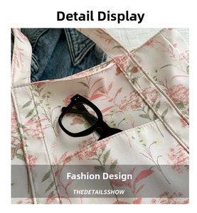 Close-up of floral tote bag pocket detail with black glasses and denim background