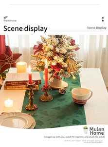 Close-up of forest green Christmas table runner with jacquard tree patterns and candles