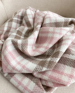 Close-up of pink and brown plaid cashmere scarf texture with soft fringe details