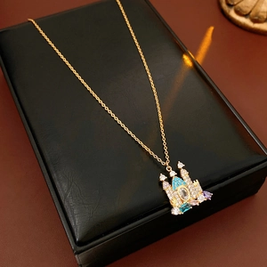 Detailed view of a gold castle pendant necklace with colorful crystals on a black jewelry box