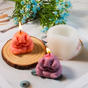 Detail of cute hamster silicone candle mold with finished handmade wax candles on wood