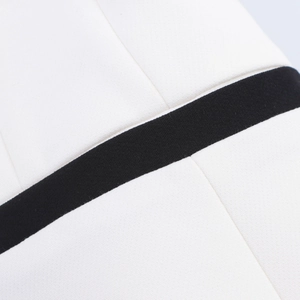 Close-up of white woven fabric with contrasting black trim detail on the suit set