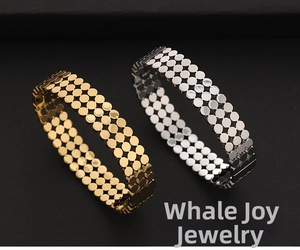 Détail de bracelets larges plaqués or 18 carats et argent avec motifs à pois