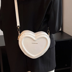 Primo piano della borsa a tracolla bianca a forma di cuore con dettagli in metallo dorato
