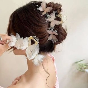 Detail of fabric butterfly hair claw clips with elegant pearls and beads decoration
