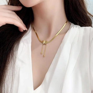 Golden titanium steel butterfly tassel necklace on model with frosted finish pendant