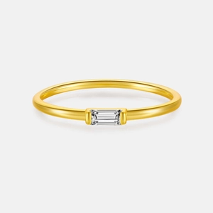 Détail macro d'une bague fine dorée classique sertie d'une pierre précieuse rectangulaire
