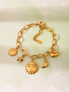 Detailansicht eines goldfarbenen Edelstahl-Armbands mit Sonnen-, Stern- und Herzanhängern