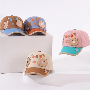 Detail of four colorful kids baseball caps with cute bear prints and B-letter charms
