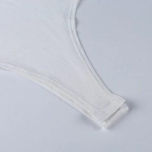 Close-up of white ribbed knit bodysuit featuring functional snap button bottom closure