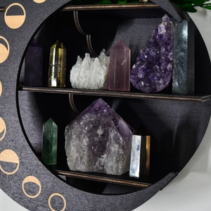 Detail of round wooden boho crystal shelf showing moon phase design and stone display