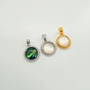 Detailed macro view of 18K gold-plated shell pendants with sparkling zircon stone inlay