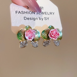 Detail of pink rose stud earring with green leaves and micro-paved crystal accents