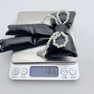 Digital scale showing the weight of 16.6g for the black leather bow pearl keychain