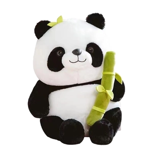 Adorable black and white panda plush pillow toy holding green bamboo on white background