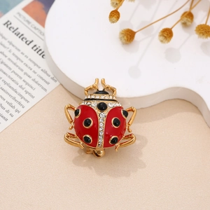 Macro view of creative ladybug brooch with red enamel and sparkling rhinestones