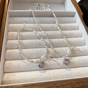 Detail of silver pearl necklace and bracelet set with pink heart pendants in a wood box