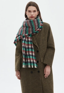 Detail showing colorful plaid scarf texture paired with an olive green wool coat