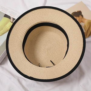 Detail view of straw hat interior with black sweatband and adjustable drawstring