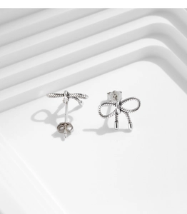 Macro shot of S925 sterling silver bow earrings with vintage twisted texture details