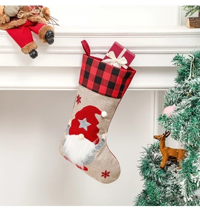 Detail of burlap gnome Christmas stocking hanging on fireplace with festive decor