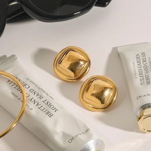 Close-up of vintage golden square titanium steel earrings with a polished finish