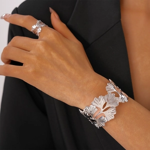 Gros plan du bracelet jonc et de la bague assortie en feuille de ginkgo argentée polie