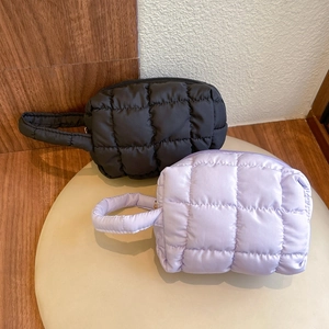 Minimalist quilted square cosmetic bags in black and lavender with zippers and handles