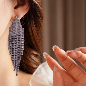 Close-up of elegant purple rhinestone tassel earrings worn on model for a luxury look