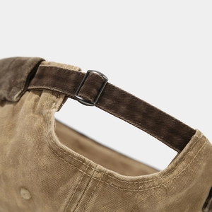 Détail de la boucle métallique et de la sangle en toile sur un bonnet rétro