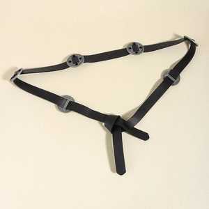 Detail of vintage black leather belt featuring ornate round metal studs and a knot finish